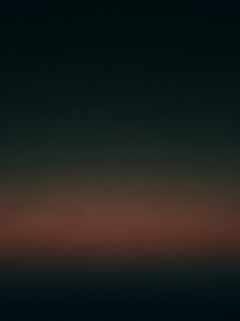 A smooth gradient background transitions from dark charcoal grey to a warm reddish-brown horizon line and back to dark grey.の素材