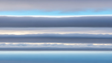 Horizontal bands of layered clouds in shades of grey blue and white with a bright light source visible between layers.の素材