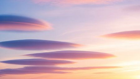 showing lenticular clouds in soft pastel pink, purple, and yellow hues at sunset or sunrise, creating a surreal and dreamlike atmospheric sky scene.の素材