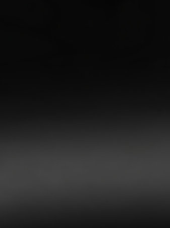 A smooth, dark gray gradient transitions subtly from a deep black at the to a lighter gray at the bottom, creating a soft, atmospheric background.の素材