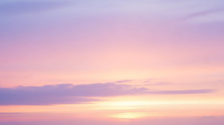 A soft pastel sky blends shades of pink, purple, and yellow with delicate, wispy clouds near the horizon.の素材
