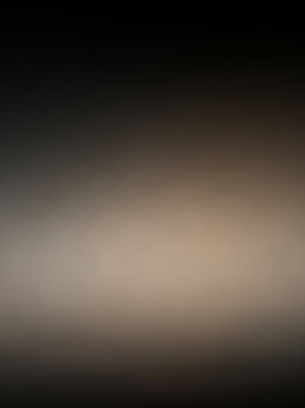 Beige showing soft focus gradient background with subtle texture transitioning from dark charcoal gray to light beige and back to dark gray, creating a moody and...の素材