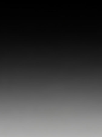 Black showing smooth vertical gradient transitioning from solid black at the to light gray at the bottom creating a dark to light abstract background effect...の素材