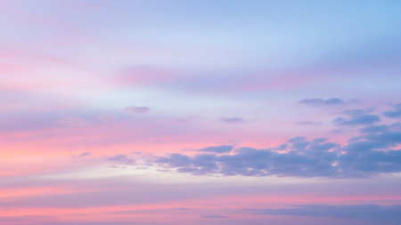Wispy clouds in soft pastel pink, lavender, and pale blue hues stretch across the sky, evoking a serene and dreamy atmosphere at dawn or dusk.の素材