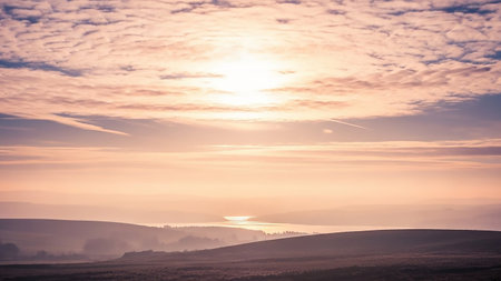 Rolling showing soft sunrise over rolling hills and a distant lake with wispy pink clouds and a gentle hazy atmosphere. resolutionの素材