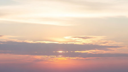 Rays showing soft pastel sky at sunrise or sunset with delicate clouds and gentle sun rays breaking through in a serene and tranquil atmospheric scene keywords:...の素材