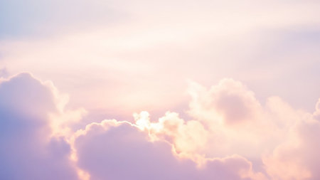 Soft pastel pink and lavender clouds are illuminated by gentle sunlight, creating a dreamy and ethereal sky effect.の素材