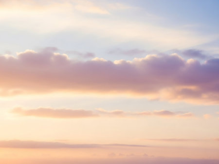 A serene sky filled with soft, pastel clouds in shades of pink, peach, and pale blue, suggesting a gentle sunrise or sunset.の素材