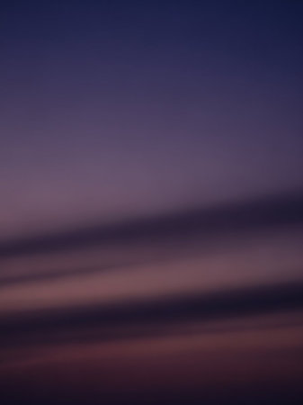 A deep purple twilight sky horizontal streaks of muted pink and grey clouds, creating a dramatic and atmospheric natural backdrop.の素材