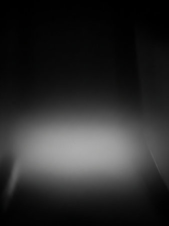 A dark, abstract background with a soft, bright gradient in the center and subtle vertical light streaks on the sides.の素材