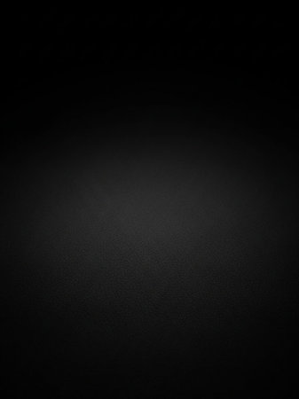 A deep black textured background with a subtle gradient and a fine grain pattern, creating a dark and minimalist aesthetic.の素材