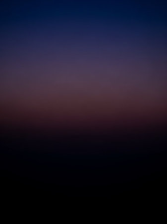 A smooth gradient transitions from deep indigo blue at the to dark purple and finally to solid black at the bottom, creating a serene, abstract effect.の素材