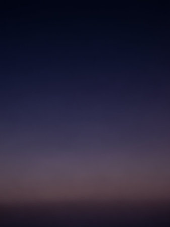 A smooth gradient of deep navy blue at the fades into soft purple and pink tones near the subtle horizon line.の素材