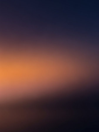A soft, blurred gradient background transitions smoothly from deep navy blue to warm orange and dark brown, creating a subtle visual effect.の素材