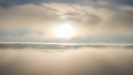 Wispy showing bright sun shining through a thick layer of soft, wispy clouds creating a diffused light effect. resolution use.の素材