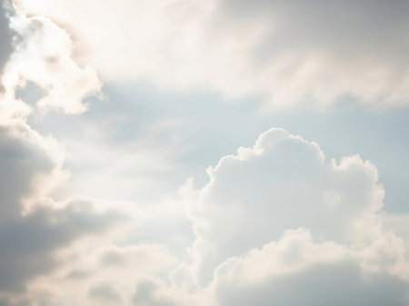 Bright white and soft grey cumulus clouds are illuminated by strong sunlight, creating a luminous and airy atmosphere with gentle light.の素材