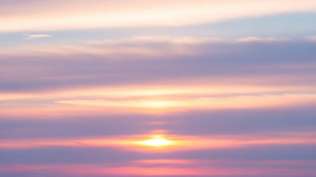 A soft pastel sunset hazy pink and lavender clouds, with the warm glow of the setting sun creating a tranquil atmosphere.の素材