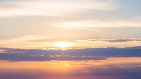 Horizon. showing serene sunset sky with soft orange and purple hues illuminating wispy clouds and a bright sun peeking through the horizon keywords: sunset, sky,...の素材