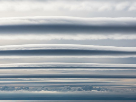 Aerial showing layered lenticular clouds forming horizontal bands across a serene sky above a distant horizon of land and sea keywords: lenticular clouds,...の素材