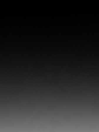 A smooth, dark gradient transitions from black at the to a lighter gray at the bottom, creating a subtle and clean background effect.の素材