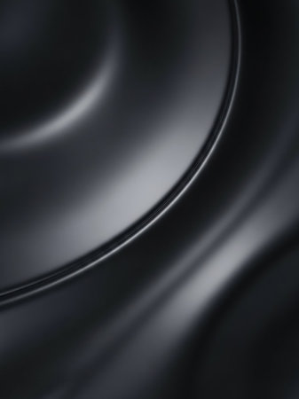 A close-up of a dark gray metallic liquid surface with soft, flowing curves and subtle reflective highlights, creating a smooth, texture.の素材