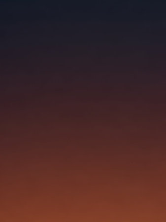 A smooth vertical gradient transitions from deep navy blue at the to warm burnt orange and brown at the bottom, suggesting twilight or sunset.の素材