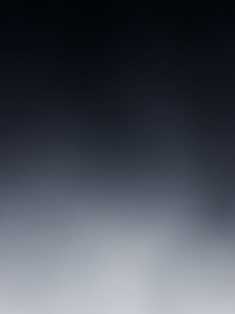 A smooth gradient transitions from deep dark blue at the to a soft light gray at the bottom with a subtle atmospheric blur effect.の素材