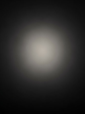 Stock showing softly lit dark gray gradient background with a central bright white and light gray circular spotlight effect creating a subtle and minimalist...の素材