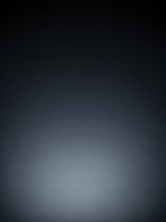 Shadow showing softly lit dark grey gradient background with a subtle illuminated floor creating a minimalist and atmospheric backdrop for various applications and...の素材