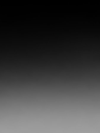 A vertical gradient transitions smoothly from deep black at the to a light gray at the bottom, with a subtle texture.の素材