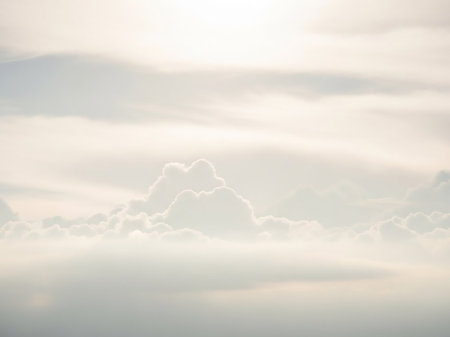Softly focused white and pale yellow clouds create a serene, airy atmosphere with a gentle luminous glow from the sun.の素材