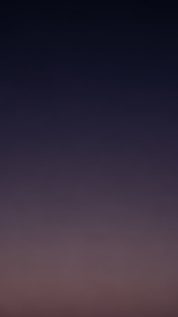 A smooth gradient background transitions seamlessly from a deep indigo blue at the to a soft, muted purple and pink hue at the bottom, creating a serene and...の素材