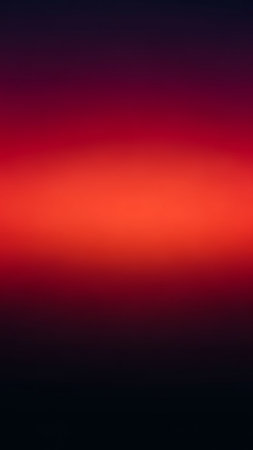 A smooth, vibrant gradient transitions from a deep crimson red through bright orange to a dark black, creating an abstract, intense color field.の素材