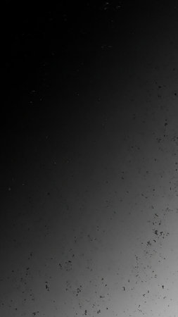 A dark gray textured background with subtle speckles and a faint gradient from light to dark, creating a gritty and distressed feel.の素材