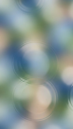 An abstract, blurred background soft circular shapes with concentric rings, reminiscent of water ripples, in muted blue, green, and beige tones.の素材