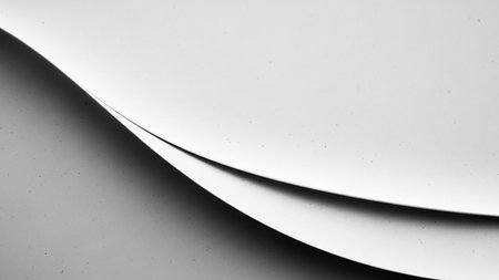 Abstract monochrome featuring curved layers of white paper creating soft shadows and subtle highlights with a fine textured surface.の素材