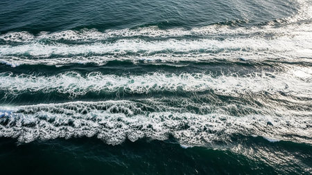 Aerial view of dark teal ocean water with distinct white boat wake trails forming parallel lines and intricate ripple patterns.の素材