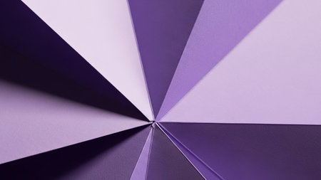 A dynamic abstract pattern of sharp triangular segments in various shades of purple and lavender, radiating outwards from a central point.の素材