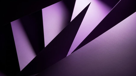 Sharp purple geometric paper shapes overlap creating a dynamic composition with strong shadows and highlights against a dark background.の素材