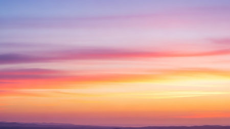 A soft gradient of pastel colors including pink orange yellow and purple fills the sky with delicate wispy clouds creating a serene and tranquil atmospheric background.の素材