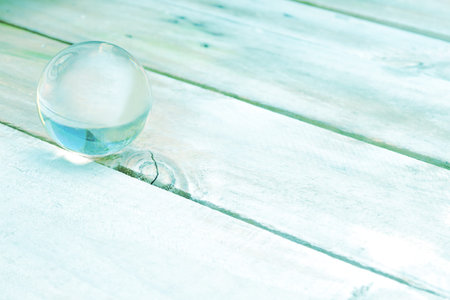 Abstract picture of glass ball on wooden floor, pastel color idea of fortune the best future for background, greeting cards, happiness festival, New years wishes, Valentine dayの写真素材