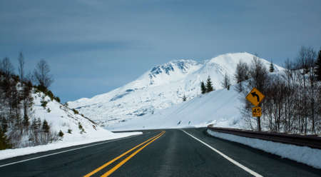 a clean road towards a snow capped mountain. Also symbolizes the path towards a peak or towards qrowth.の写真素材