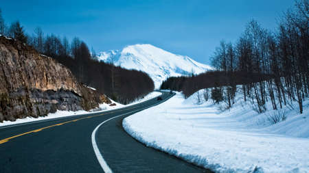 a clean road towards a snow capped mountain. Also symbolizes the path towards a peak or towards qrowth.の写真素材