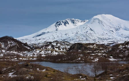 A high altitude clear water lake in front of a snow capped mountain peak.の写真素材