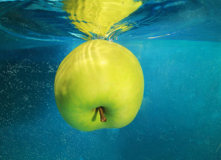 apple in water on a blue backgroundの写真素材