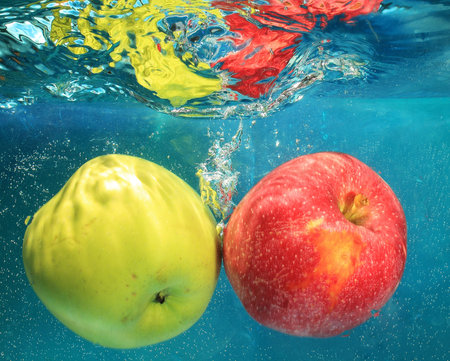 apple in water on a blue backgroundの写真素材