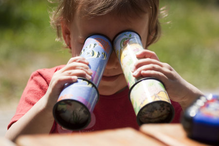 Little Kid playing with two Kaleidoscopeの写真素材