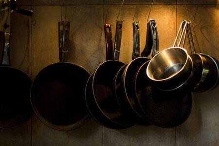 Pans hanging on kitchen wallの写真素材