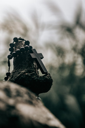 Wooden rosary with cross - with bokeh in backgroundの写真素材