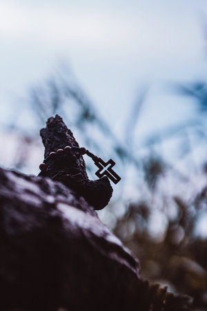 Wooden rosary with cross - with bokeh in backgroundの写真素材